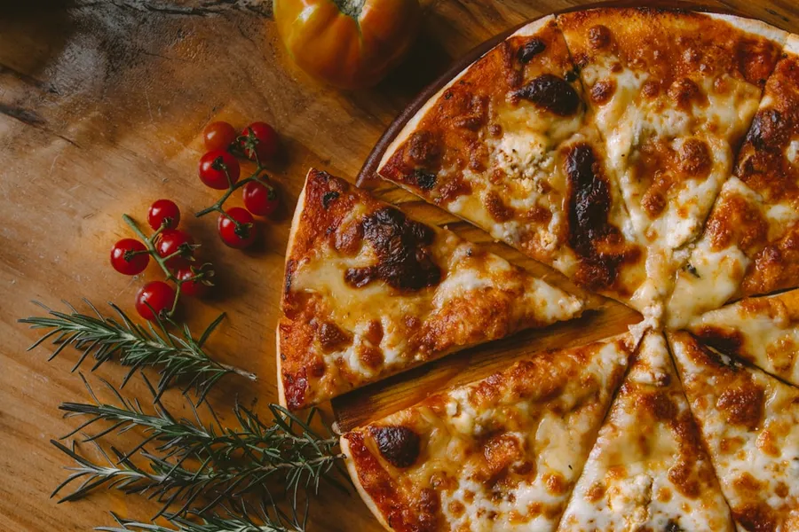 Steinofen-Pizza mit frischem Rosmarin und Tomaten